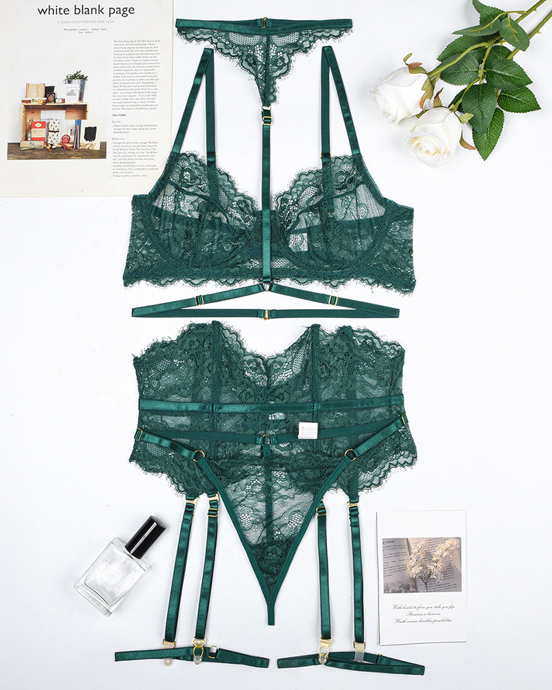 Green lace bra and panty set with garter belt, pieces laid out flat