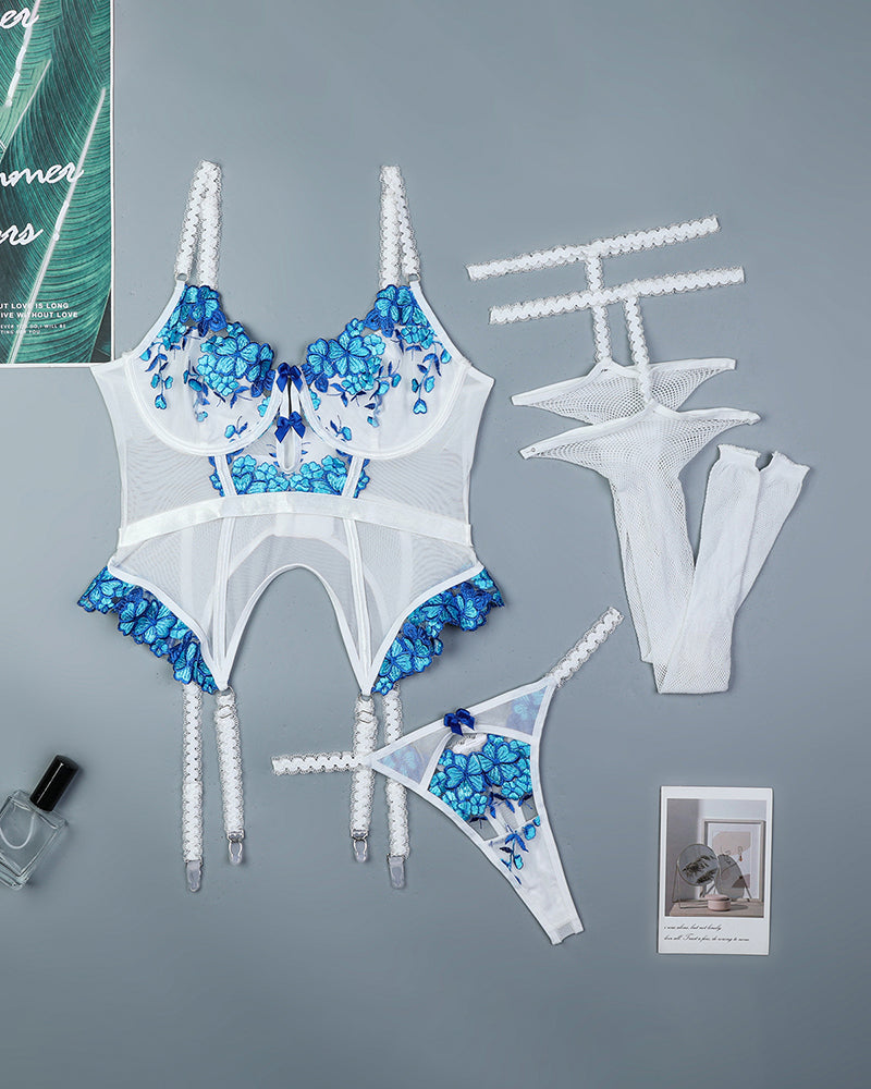 White and blue embroidered corset set with matching stockings and garters, flat lay
