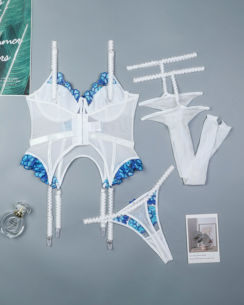 White and blue embroidered lingerie set with garters and stockings, flat lay pieces