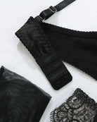 Black adjustable bra strap hooks and lace garter belt fabric detail