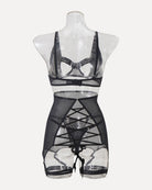 Black mesh lingerie on mannequin with strappy cutouts and garter straps