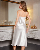 White satin slip nightdress with lace trim and spaghetti straps, open back view.