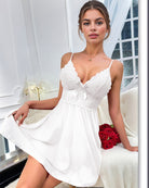 White lace slip dress with bow at bust, scalloped neckline and flared skirt