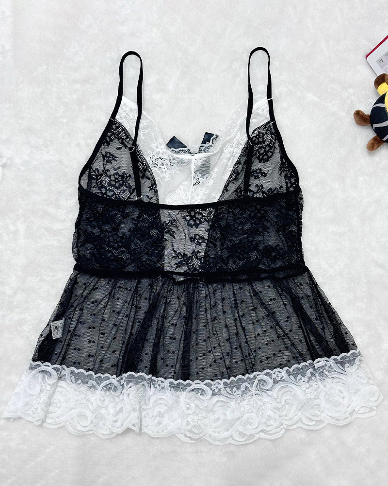Flat lay of black sheer lace maid set with white scalloped lace hem and layered ruffles