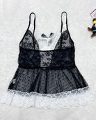 Flat lay of black sheer lace maid set with white scalloped lace hem and layered ruffles