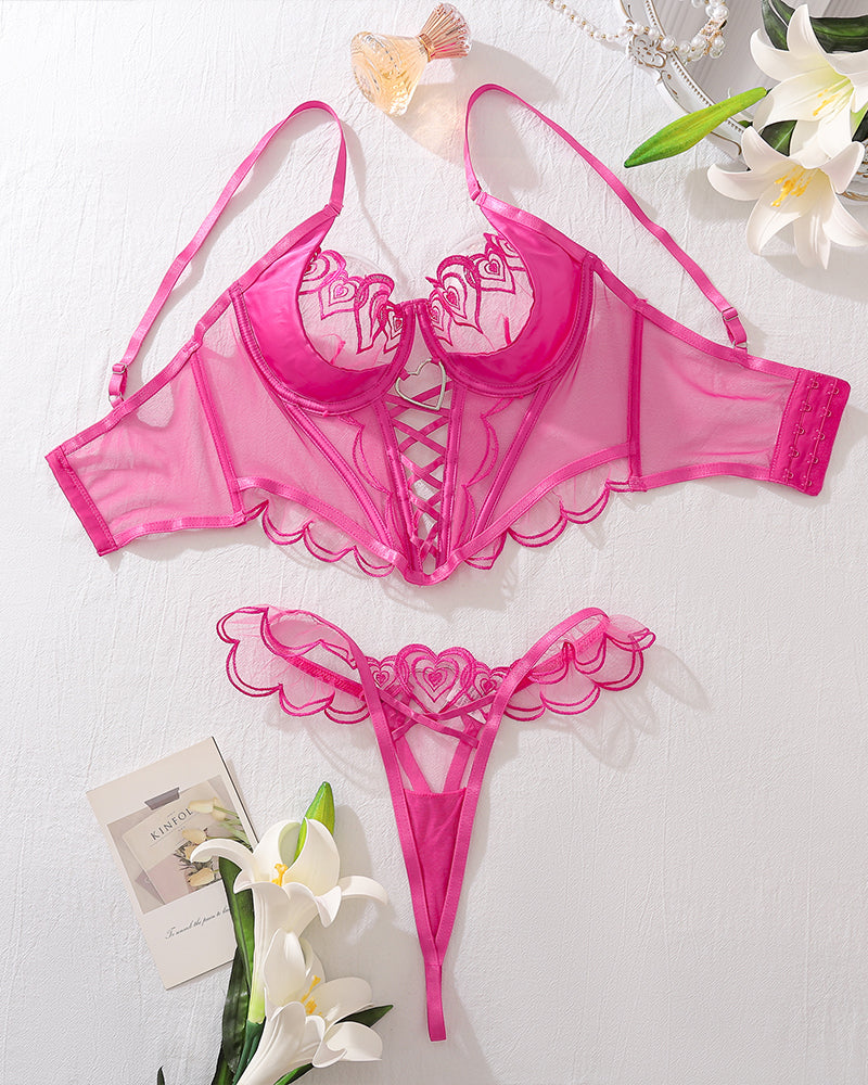Two-piece lingerie corset set flat lay, rose pink heart bra and lace-up corset with thong