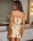 Champagne satin backless slip dress with thin adjustable straps and flared ruffle hem