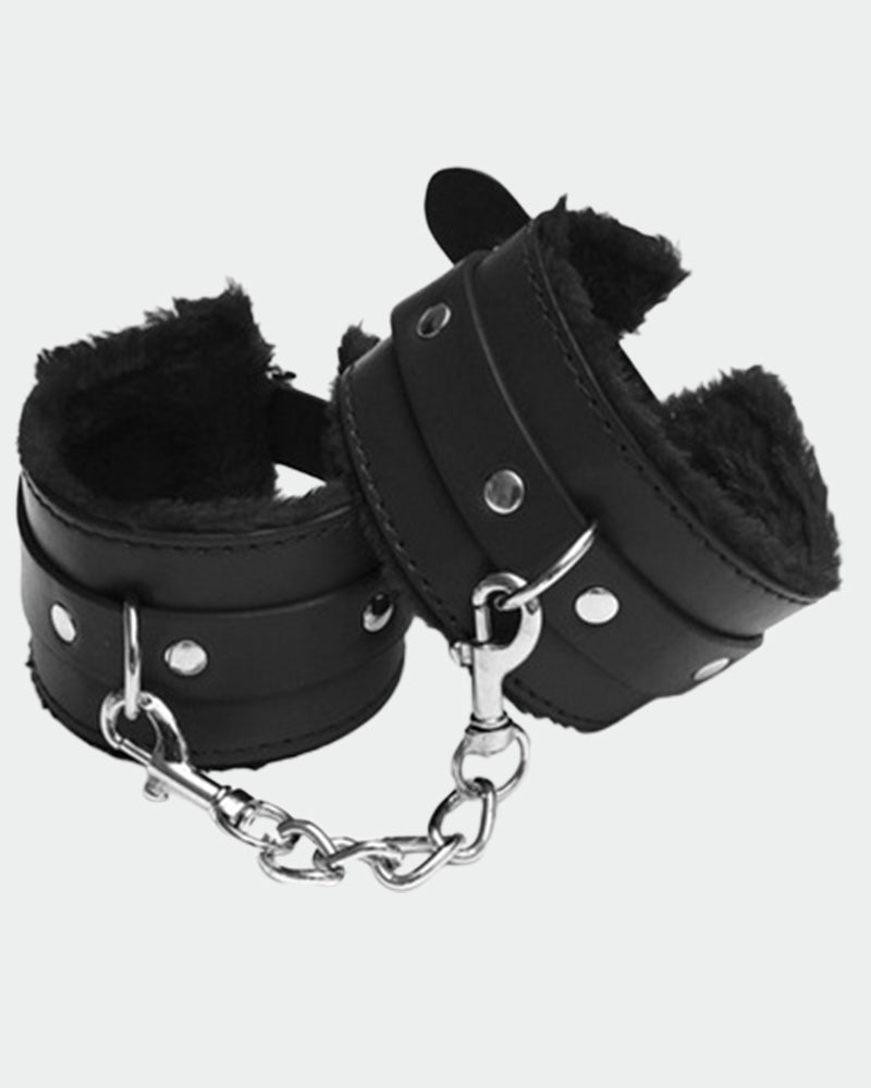 Black leather plush handcuff-style wrist restraints with silver chain and round studs