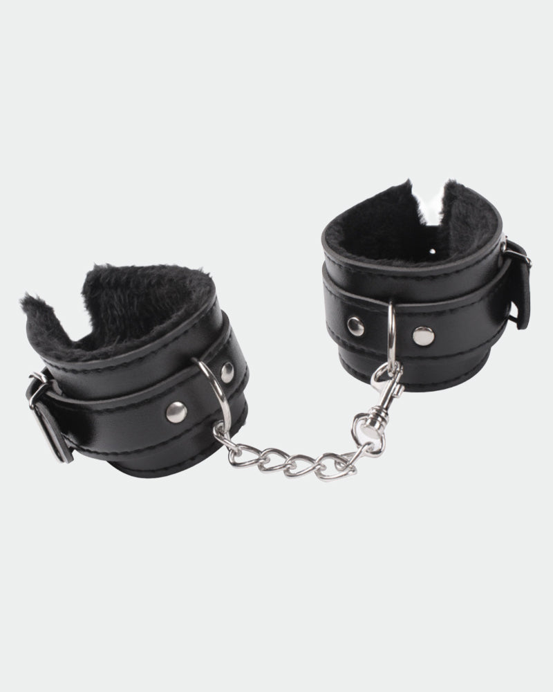 Pair of black leather plush wrist cuffs with hinged buckles and silver chain