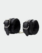 Black leather plush wrist cuffs viewed from side with metal buckles and chain links