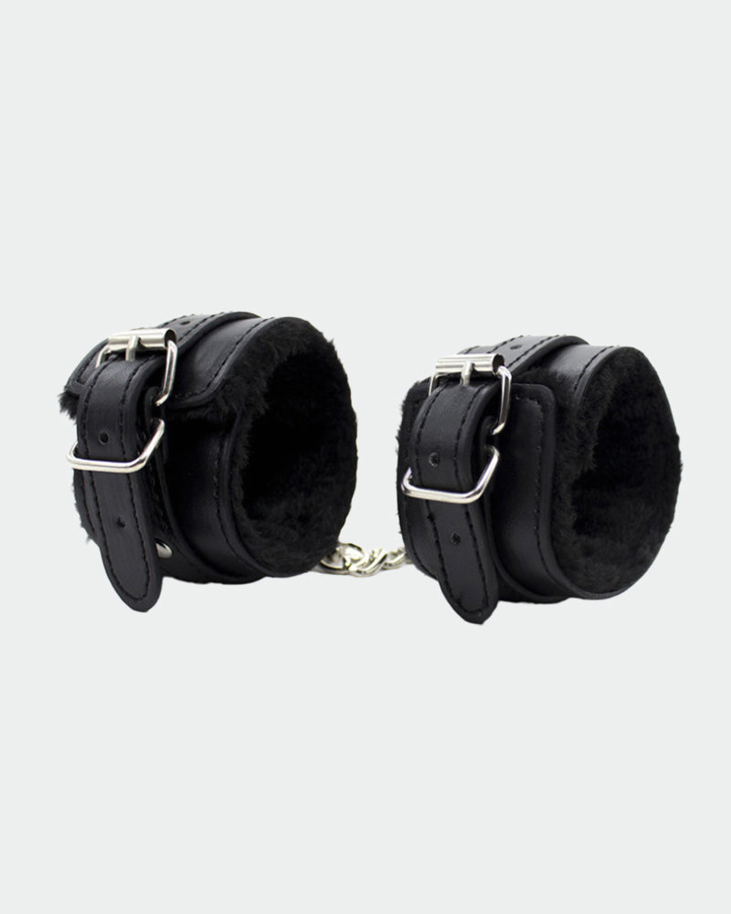 Black leather plush wrist cuffs viewed from side with metal buckles and chain links