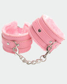 Pink leather plush wrist cuffs with silver chain links and round metal snap studs