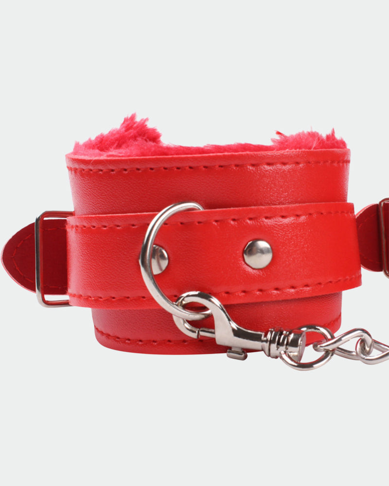 Red leather plush wrist cuff close-up with silver ring, studs, and attached chain