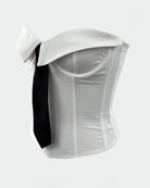 White strapless corset top with black tie ribbon detail, side view.