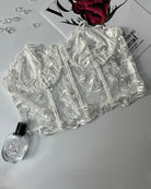 White floral strapless boned mesh bustier laid flat with rose embroidery