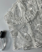 White embroidered rose mesh overlay fabric close-up for a boned bustier