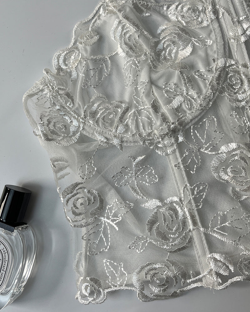 White embroidered rose mesh overlay fabric close-up for a boned bustier