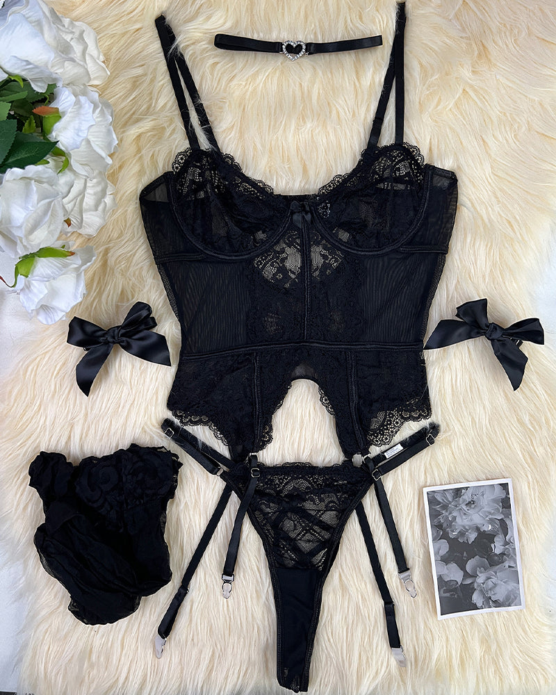 Black lace lingerie set flat lay: corset, thong, garters, bows, and matching stockings