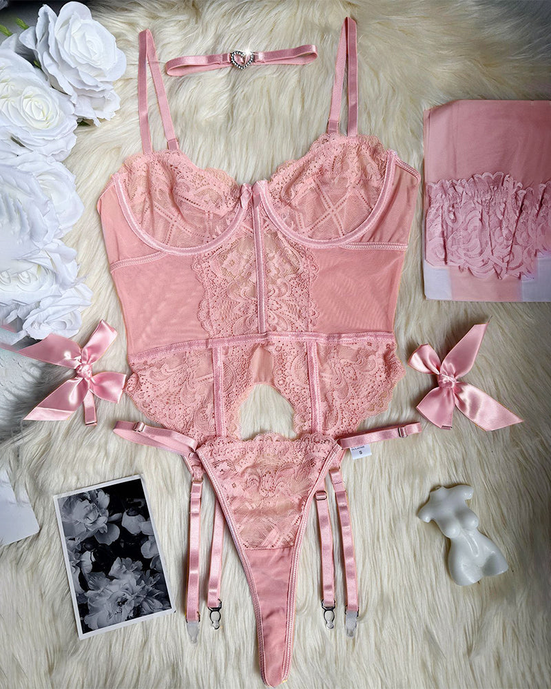 Pink lace lingerie set flat lay: corset, thong, garters, bows, and matching stockings