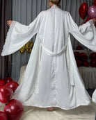 White satin belted robe with contrast lace trim, back view with tied waist and flared hem.
