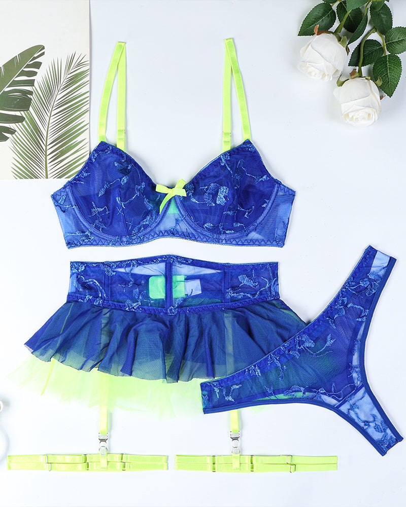 Flat lay: blue lace underwire bra, layered mini skirt, and matching blue thong with neon trim