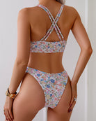 White floral triangle bikini set with crisscross back straps and matching high-cut bottoms