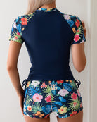 Navy rash guard top and tropical floral shorts set, back view, tie waist