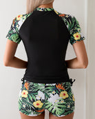 Black rash guard top and tropical floral shorts set, back view, tie waist