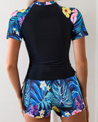 Navy rash guard top and colorful tropical floral shorts set, back view, tie waist