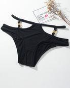 Black panties with thin straps and gold metal button accents