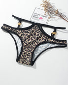 Leopard print panties with thin black straps and gold metal button accents