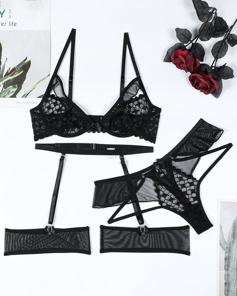 Black lingerie set flat lay: lace half-cup bra, garter belt, panties, and stockings.