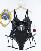 Black faux leather and mesh lingerie bodysuit on hanger with tie garter straps