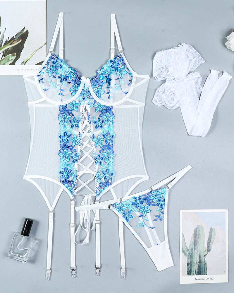Blue floral embroidered lingerie set flat lay with bra, corset, garters, stockings