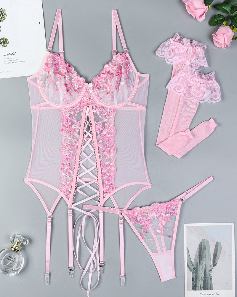 Pink floral embroidered lingerie set with bra, corset-style panel, garters, and stockings