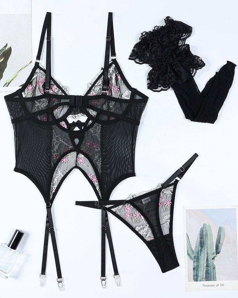 Black floral-embroidered lingerie set flat lay with bra, bodysuit, thong, and stockings