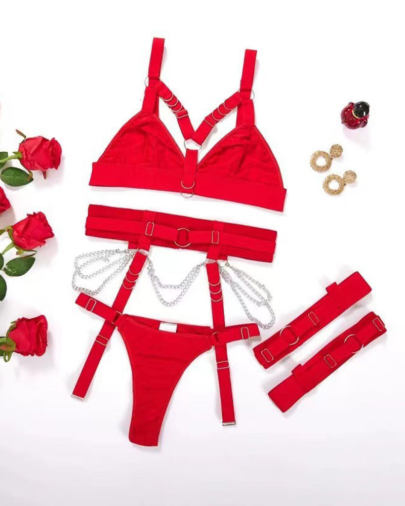 Red metal chain strap bra set flat lay: bra, thong, garter straps, and chain accessories