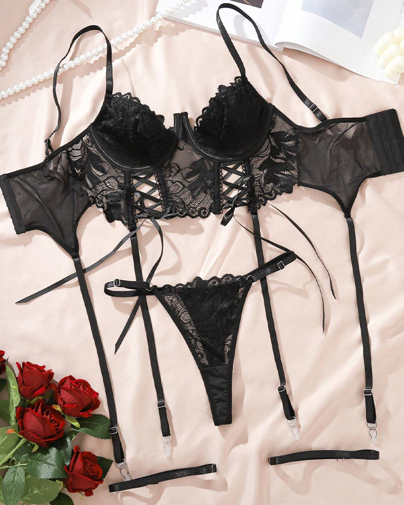 Black lace lingerie set with bra, corset front lacing, thong, and garter straps—flat lay