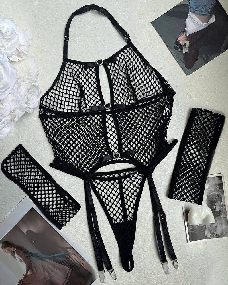 Black fishnet lingerie set laid out: bra, thong, garters, and thigh-high stockings