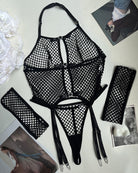 Black fishnet lingerie set laid out: bra, thong, garters, and thigh-high stockings