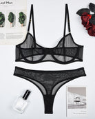 Black sheer mesh underwire bra and thong panty set, flat lay