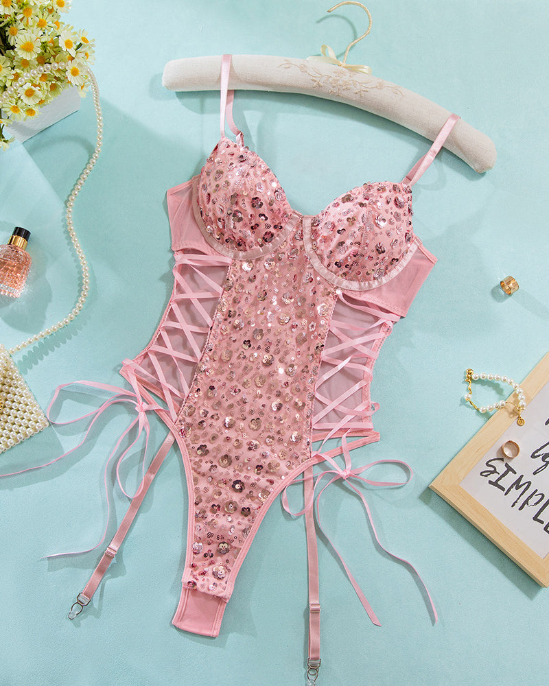 Pink sequin mesh bodysuit on hanger with lace-up sides and garter straps