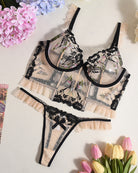 Lace-embroidered underwire bra and panty set with black floral embroidery, laid flat