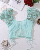 Light green embroidered bralette top with scalloped trim and lace-up ties, flat lay