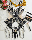 Black lace corset lingerie set flat lay with floral embroidery and garter straps
