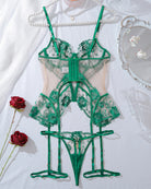 Green lace corset lingerie set flat lay with floral embroidery and garter straps