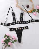 Black butterfly print lingerie set: chain-strap bra top and matching thong, flat lay
