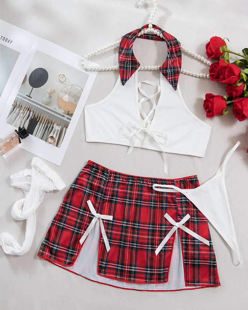 Flat lay lingerie set: white lace-up bra, red-black plaid mini skirt, fishnet stockings