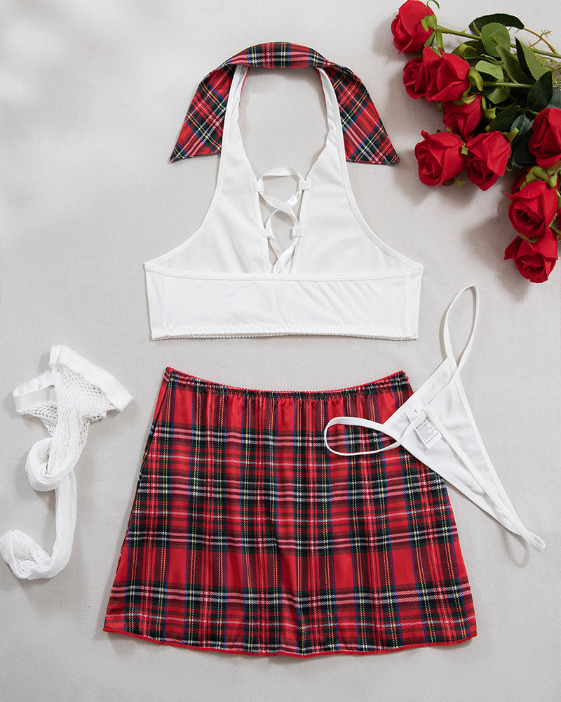 Flat lay costume lingerie set with white lace-up bra, plaid mini skirt, and fishnet stockings