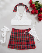 Flat lay costume lingerie set with white lace-up bra, plaid mini skirt, and fishnet stockings